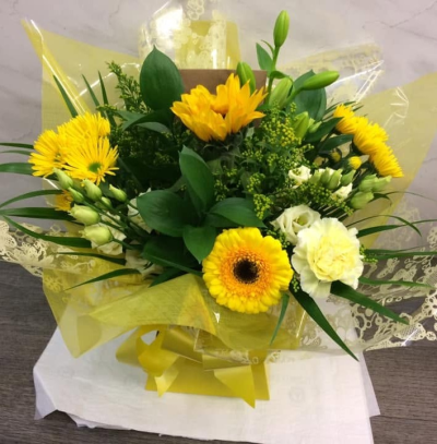 Lemon Drop - A bright front-facing arrangement in cheerful yellow and soft cream tones, complemented by fresh greenery and sunny wrapping.