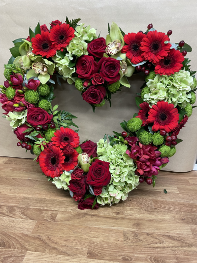 Open Heart - A stunning open heart funeral tribute, beautifully arranged in rich shades of red, deep burgundy and soft green. This elegant design symbolises everlasting love and cherished memories, offering a heartfelt and meaningful way to say a final goodbye to someone truly special.